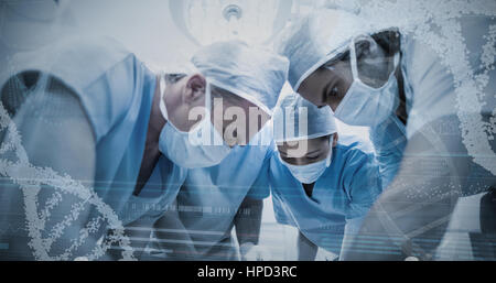 Vista panoramica di elica di informazioni di configurazione sul dispositivo schermo contro il gruppo di chirurghi di eseguire l'operazione nella camera operativa Foto Stock