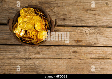 San Patrizio giorno vaso riempito con cioccolato monete d oro su sfondo di legno Foto Stock