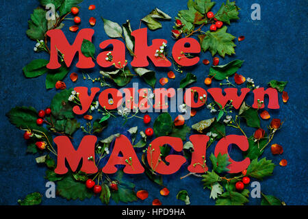 Crea la tua magia lettering con foglie di colore verde e rosso dei petali di rosa. Le lettere vengono effettuate dal pastello carta. Foto Stock