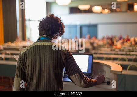 Casualy vestito giovane esperto di millenaria dando talk durante la conferenza scientifica. Pubblico presso la sala conferenze. Business e imprenditorialità evento. Foto Stock