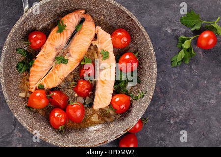 Closeup colpo di fritto bistecca di salmone con limone e verdure in padella. Foto Stock