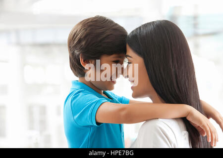 Sorridente madre e figlio di toccare fronte Foto Stock