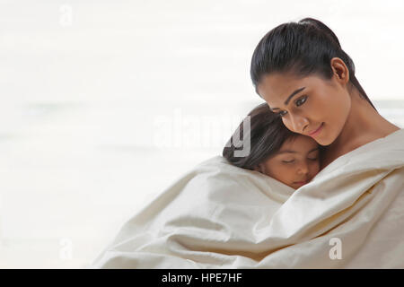 Madre e figlia avvolto in una coperta Foto Stock