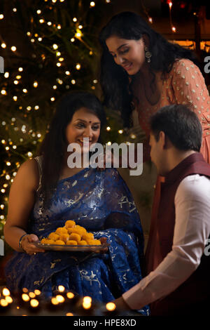 Donna con sua figlia e suo genero celebrare diwali Foto Stock