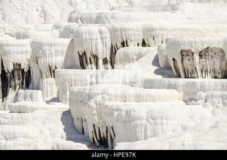 Stalattiti di Pamukkale's terrazze, fatta di travertino, una roccia sedimentaria depositato da acqua da sorgenti di acqua calda. Foto Stock