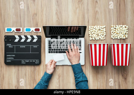 Uomo in possesso di un biglietto e la visione di un film online in streaming con popcorn, occhiali 3D e clapboard, cinema e film concetto Foto Stock