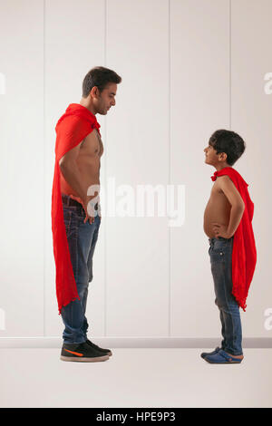Padre e figlio che agisce come super eroi Foto Stock