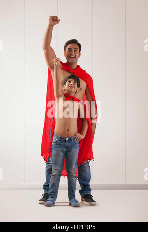 Padre e figlio che agisce come super eroi Foto Stock