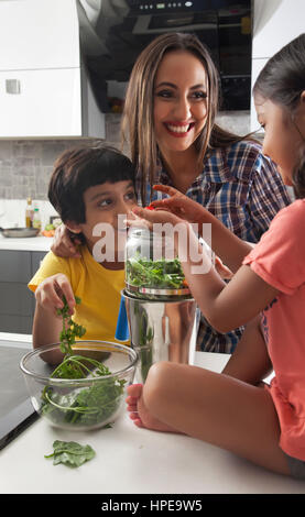 La madre con la figlia e il figlio per divertirsi insieme in cucina Foto Stock