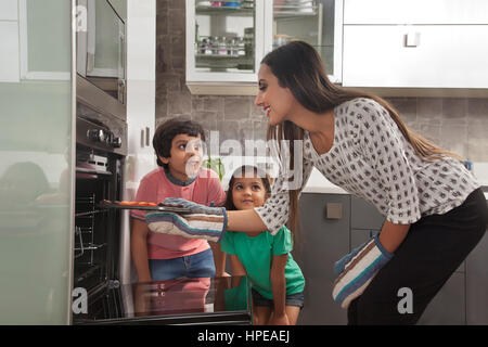 Madre con i suoi due figli la cottura in forno Foto Stock
