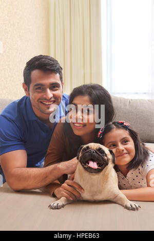 Ritratto di famiglia sorridente con la figlia e pug Foto Stock