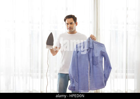 Ritratto di uomo con ferro da stiro e camicia Foto Stock