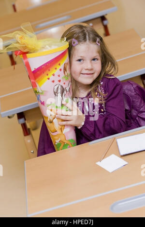 Modello rilasciato , Schulanfaengerin mit Schultuete Klassenzimmer im - bambino iniziare la scuola con la scuola di cono in aula Foto Stock