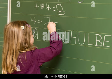 Modello rilasciato , Erstklaesslerin schreibt an der Tafel - allievo di Blackboard Foto Stock