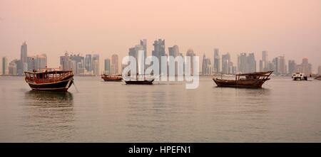 Doha, Qatar - 2 novembre 2016. Vista sullo skyline di Doha in Qatar all'alba, con grattacieli e barche Dhow. Foto Stock