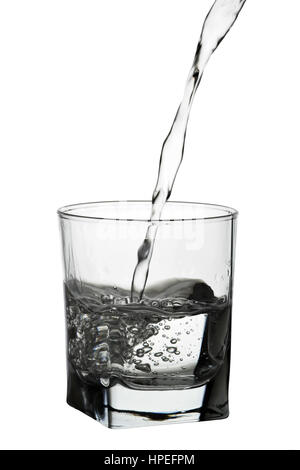 Acqua versando in vetro isolato su bianco Foto Stock