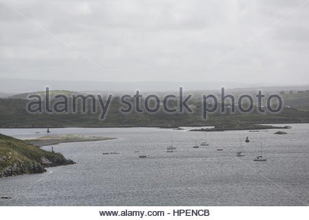 Piccole imbarcazioni si trovano in acque poco profonde lungo la costa occidentale dell'Irlanda. Foto Stock