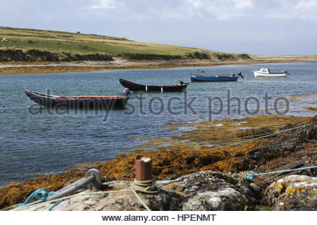 Piccole imbarcazioni si trovano in acque poco profonde lungo la costa occidentale dell'Irlanda. Foto Stock