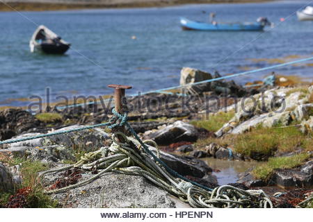 Piccole imbarcazioni si trovano in acque poco profonde lungo la costa occidentale dell'Irlanda. Foto Stock