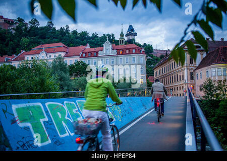 Paesaggio con Schlossberg o Castle Hill mountain con la vecchia torre dell orologio Uhrturm, da un ponte sopra il fiume Mur, Graz Foto Stock