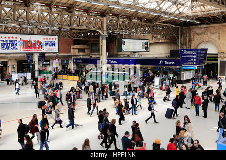 La gente dell'atrio e schede di partenza; all'interno della stazione ferroviaria di Victoria, London REGNO UNITO Foto Stock
