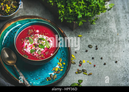 Primavera detox zuppa di barbabietole con la menta, chia, lino e semi di zucca su un blu brillante piastra ceramica su cemento grigio sfondo, copia dello spazio. Dieta, cl Foto Stock