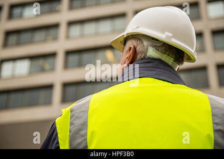 Ispettore di edificio con il suo ritorno alla telecamera. Foto Stock