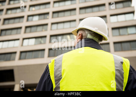 Ispettore di edificio con il suo ritorno alla telecamera. Foto Stock