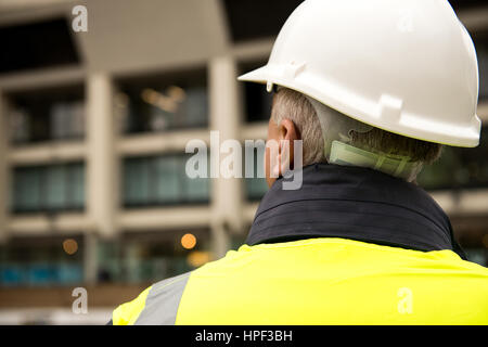 Ispettore di edificio con il suo ritorno alla telecamera. Foto Stock