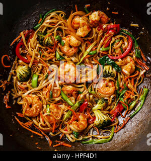 Udon friggere gli spaghetti con i gamberi in padella wok close up Foto Stock