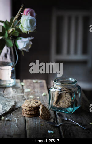 Cereali biscotti in un recipiente su un tavolo di legno Foto Stock