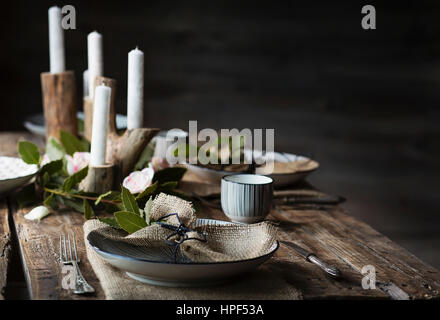 Impostazione tabella decorate con fiori di colore bianco e foglie di alloro Foto Stock