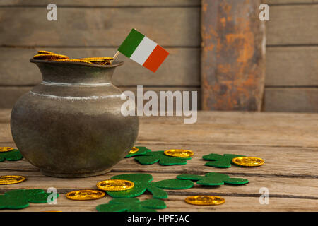 San Patrizio giorno pot di cioccolato monete d oro con bandiera irlandese e trifogli sul tavolo di legno Foto Stock