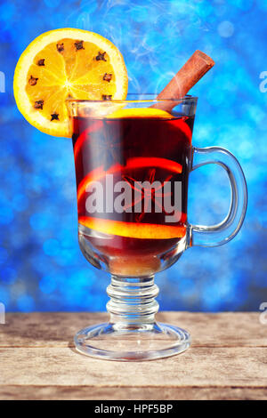 Vin brulé con la stecca di cannella fetta di arancia sul tavolo di legno con il nuovo anno bokeh sfondo. Natale vin brulé con arance e spezie Foto Stock