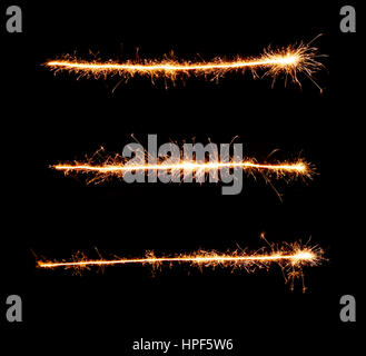 Linea orizzontale fatta di botti. Botti. Luce di bengala. Brillantini dorati su sfondo nero per la progettazione Foto Stock