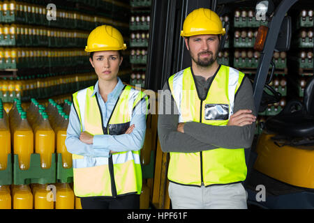 Ritratto di lavoratori in fabbrica in piedi con le braccia incrociate in fabbrica Foto Stock