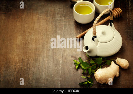 Il tè con la menta, lo zenzero e il limone su sfondo di legno Foto Stock