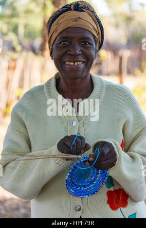 Donna dello Zimbabwe creare lavorati a mano bocce vicino al Parco Nazionale di Hwange. Foto Stock