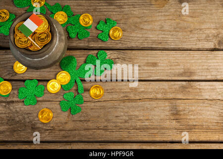 San Patrizio giorno pot di cioccolato monete d oro con bandiera irlandese e trifogli sul tavolo di legno Foto Stock