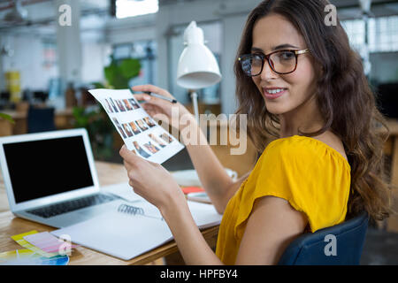 Ritratto di una femmina di graphic designer che lavora alla scrivania in ufficio creativo Foto Stock