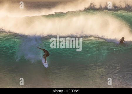 Un surf a cavallo di un onda alla tubazione sulla North Shore di Oahu. Foto Stock