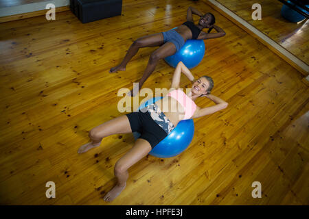 Montare due donne esecuzione pilato sulla palla ginnica in studio fitness Foto Stock