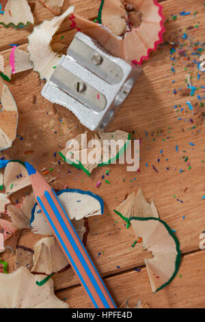 Close-up di temperino e matita colorata con trucioli su sfondo di legno Foto Stock