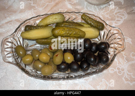Vetro della piastra relish riempito con sottaceti, pimento olive verdi ripiene & olive nere sul tavolo per la cena. Champlin Minnesota MN USA Foto Stock