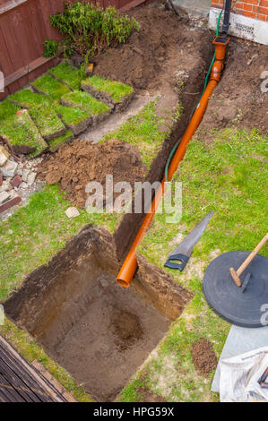 Lo scavo di un pozzo soakaway in un piccolo giardino anteriore Foto Stock