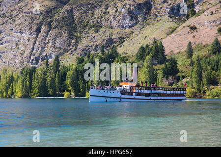 Queenstown, Otago, Nuova Zelanda. Lo storico battello a vapore TSS Earnslaw nella baia di spiaggia, sul lago Wakatipu, adiacente a Walter picchi elevati di Country Farm. Foto Stock