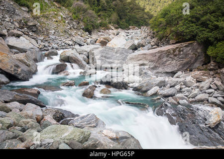 Haast Pass, montare gli aspiranti National Park, West Coast, Nuova Zelanda. La schiumatura acque del fiume Haast tumbling sulle rocce alle porte di Haast. Foto Stock