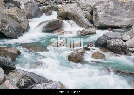 Haast Pass, montare gli aspiranti National Park, West Coast, Nuova Zelanda. La schiumatura acque del fiume Haast tumbling sulle rocce alle porte di Haast. Foto Stock