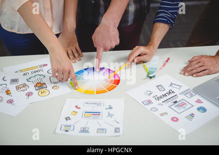 La sezione centrale del graphic designer interagire gli uni con gli altri mentre si lavora in ufficio Foto Stock