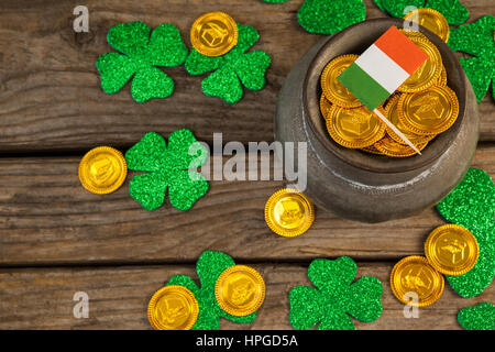 San Patrizio giorno pot di cioccolato monete d oro con bandiera irlandese e trifogli sul tavolo di legno Foto Stock